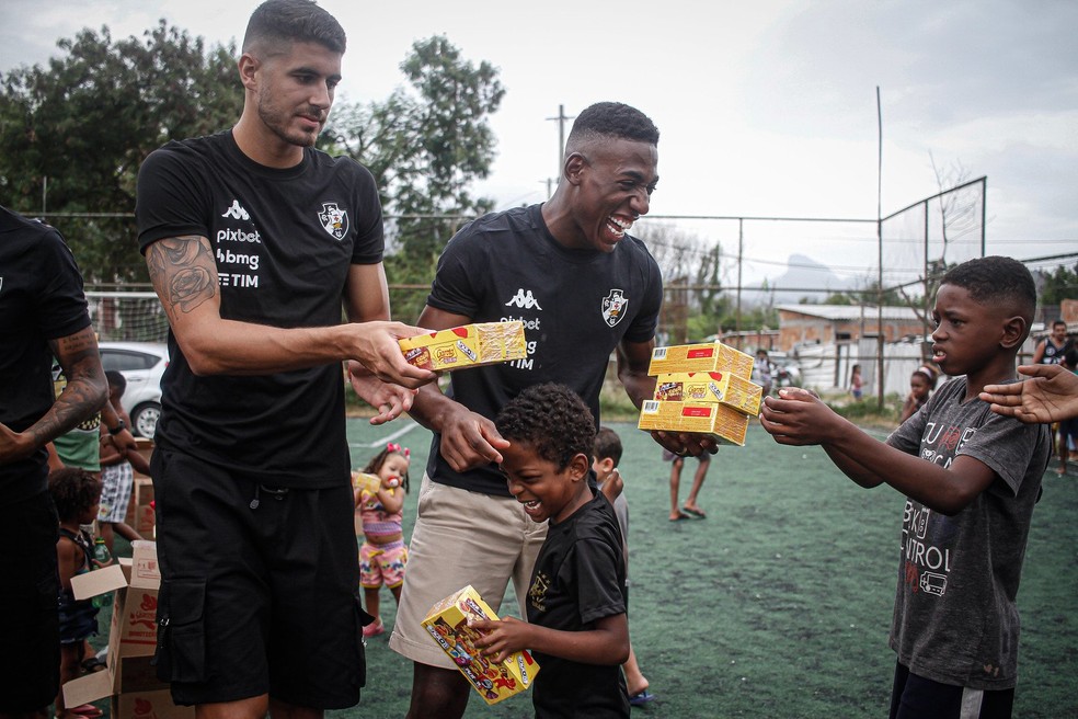 Jogadores do Vasco distribuem chocolates na Cidade de Deus — Foto: Matheus Lima / CRVG