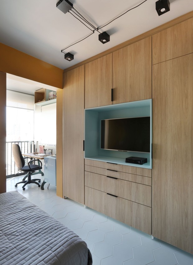 QUARTO/HOME OFFICE | O painel atrás da cama traz mais cores, que se misturam com o verde da parede (Foto: Divulgação / Mariana Orsi)