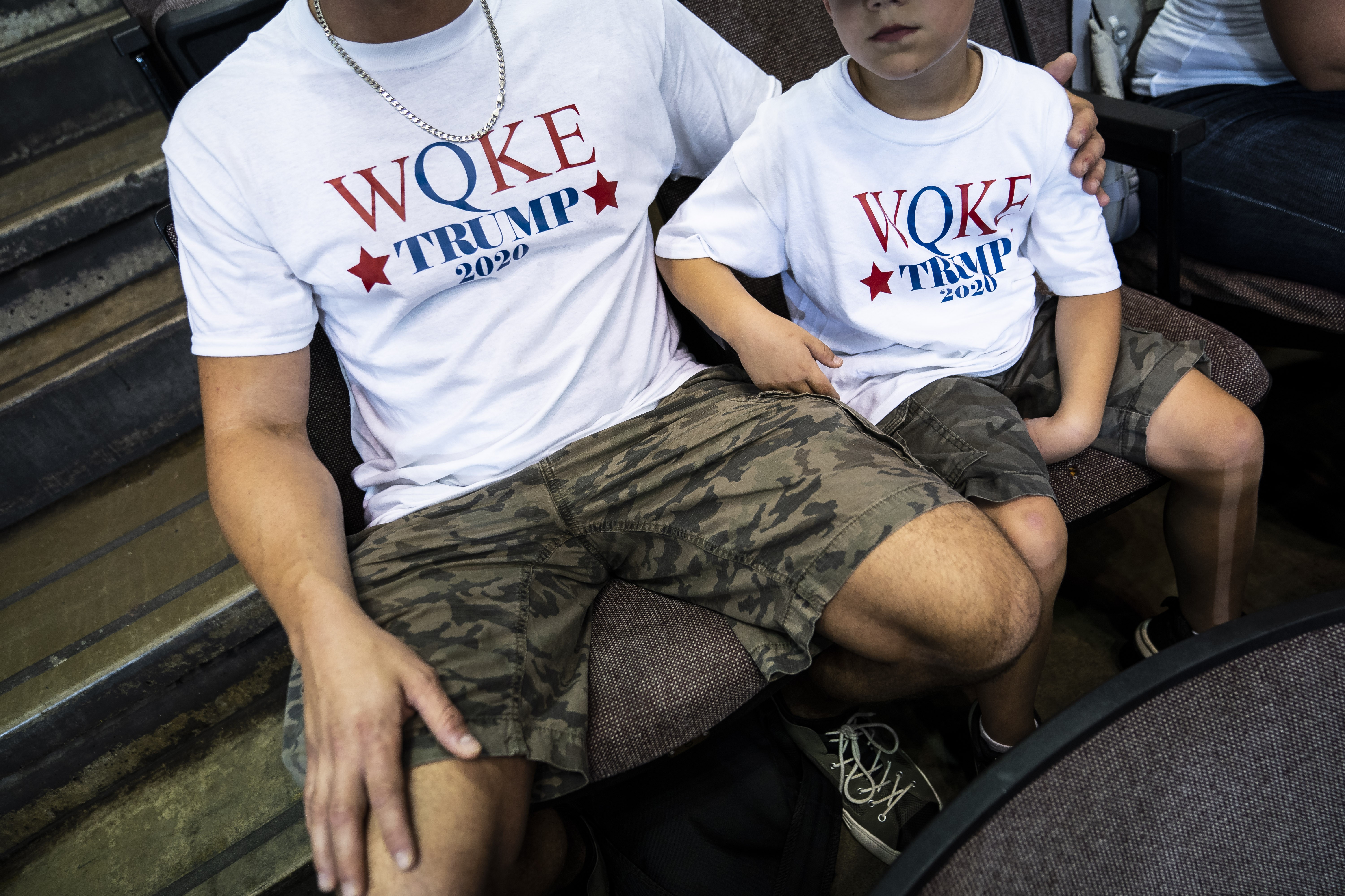 CINCINNATI, OHIO - AUGUST 1 : A father and son in QAnon shirts listen before President Donald J. Trump arrives to speak at a "Keep America Great Rally" at U.S. Bank Arena on Thursday, Aug 01, 2019 in Cincinnati, Ohio. (Photo by Jabin Botsford/The Washingt (Foto: The Washington Post via Getty Im)