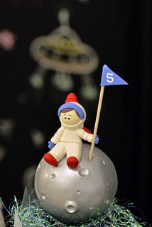 No topo do bolo, um astronauta que chegou à Lua observa os planetas