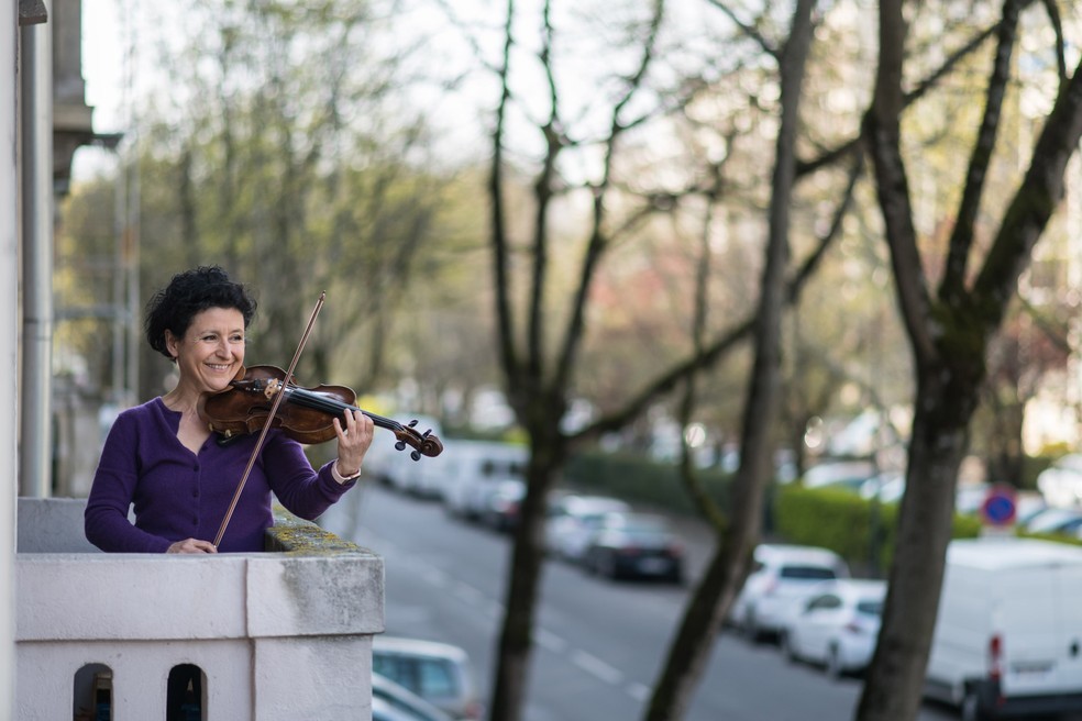 Jessy Koch, violinista da Orquestra Sinfônica de Mulhouse, se apresenta diariamente em sua varanda para apoiar os profissionais de saúde em Mulhouse, no leste da França, em 28 de março — Foto:  Sebastien Bozon/AFP