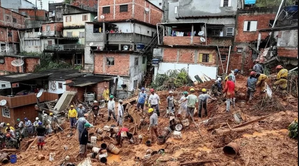 Voluntários e bombeiros procuram vítimas em escombros de deslizamento em Franco da Rocha — Foto: EPA