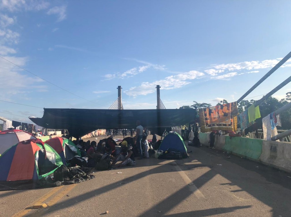 Parte dos imigrantes decidiram permanecer na Ponte de Integração para evitar a passagem de caminhões e mercadorias do Peru — Foto: Arquivo/Assistência Social de Assis Brasil