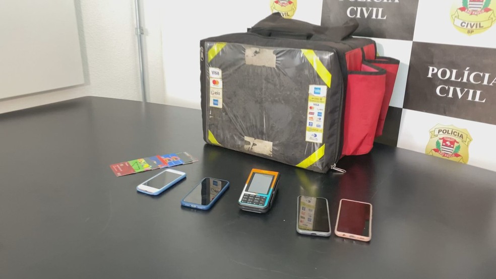 Máquina, mochila e celulares apreendidos pela polícia durante a operação do Deic de São Bernardo do Campo — Foto: Reprodução/TV Globo
