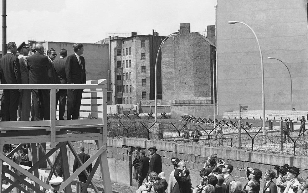 Presidente dos EUA à época, John Kennedy observa o lado oriental de Berlim por cima do muro, de uma plataforma, em foto de junho de 1963 — Foto: AP/Arquivo