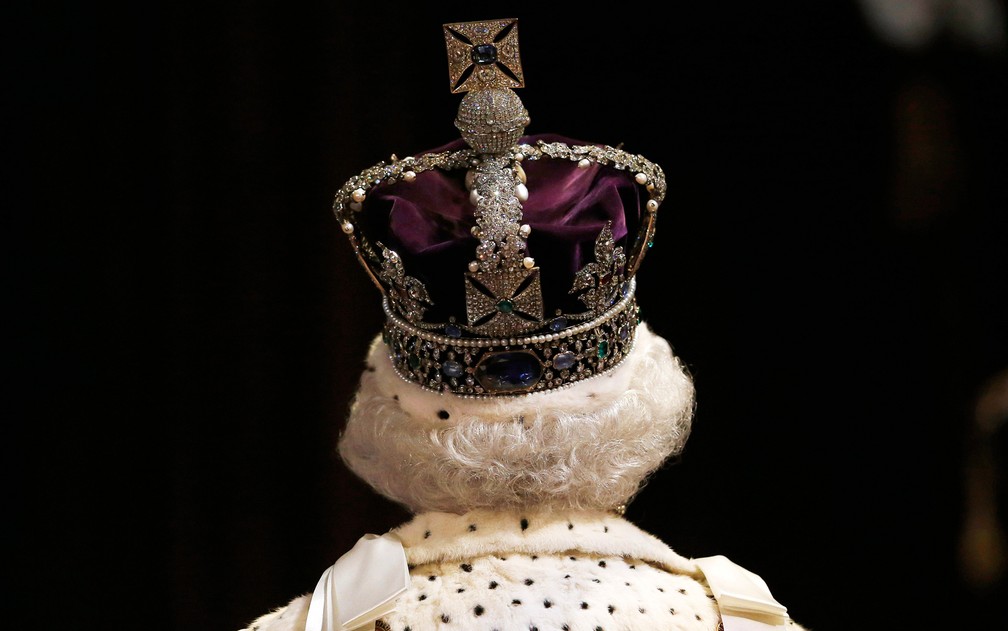 Rainha Elizabeth II chega ao Parlamento britânico usando a coroa imperial. O discurso da rainha marca o início do ano parlamentar britânico — Foto: Suzanne Plunkett/AFP