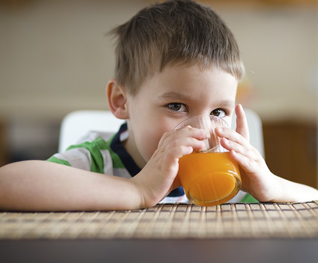 Little boy is drinking orange juice using straw (Foto: Getty Images/iStockphoto)
