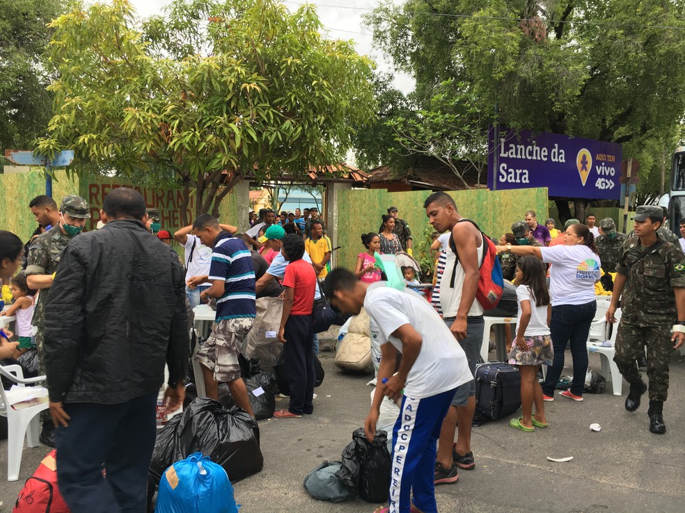 Imigrantes deixam praça Capitão Clóvis, no Centro, para serem levados a abrigo temporário  (Foto: Emily Costa/G1 RR)