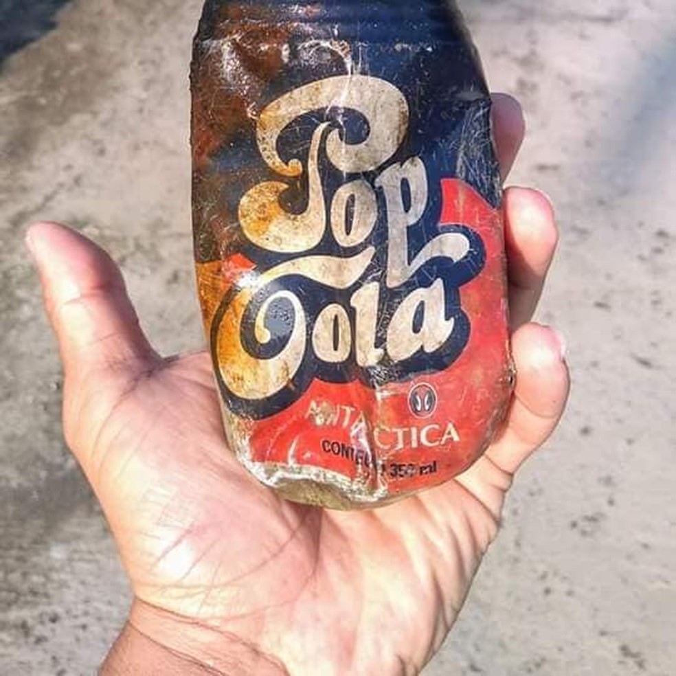 Uma latinha de alumínio de refrigerante produzida há mais de 20 anos foi encontrada na areia da praia na Ilha das Palmas — Foto: Renato Miranda