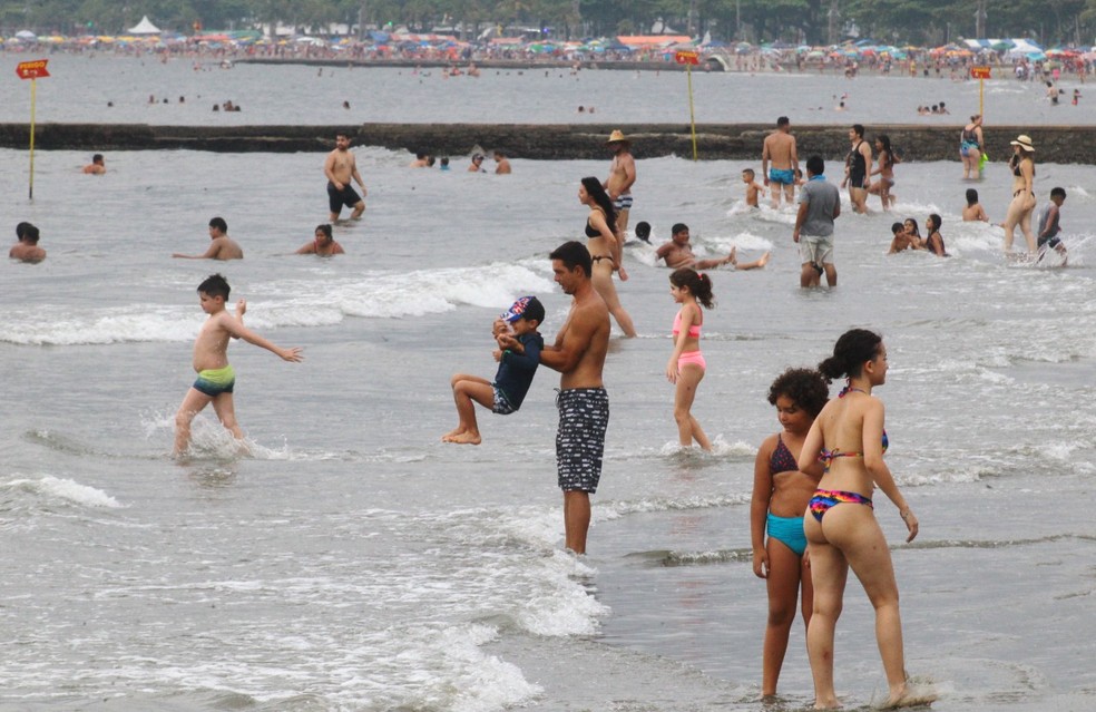 Turistas ignoram temporais e lotam as praias no primeiro dia do ano em Santos, SP — Foto: Matheus Tagé/Jornal A Tribuna