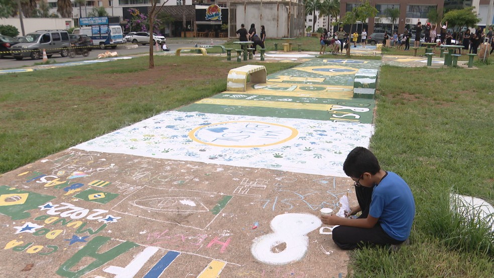 Alunos se reúnem e pintam praça de verde e amarelo em Águas Claras, no DF — Foto: TV Globo/Reprodução