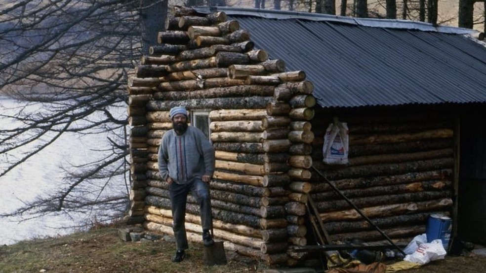 Ken em sua cabana de troncos, pouco depois de terminar a construção dela em meados da década de 1980 — Foto: Ken Smith/BBC