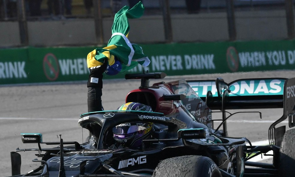 Lewis Hamilton reproduziu gesto de Ayrton Senna com a bandeira do Brasil após vitória no GP de São Paulo da F1 — Foto: AFP