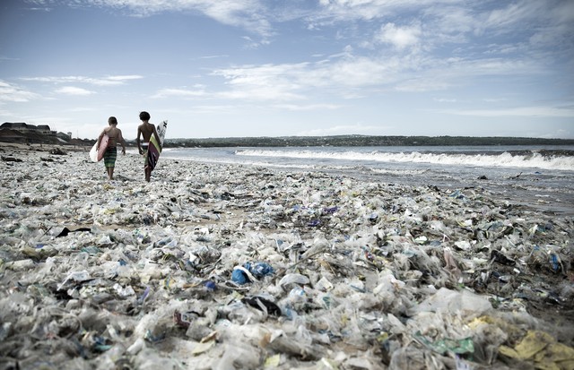 Crianças surfam em praia lotada de lixo (Foto: Divulgação/Vogue Internacional)