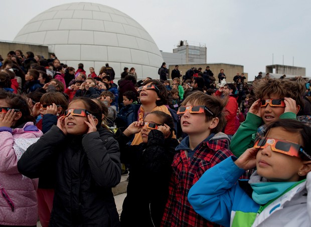 MADRID, SPAIN - MARCH 20: Children use special glasses to look into the sky during a partial solar eclipse outside the Planetario on March 20, 2015 in Madrid, Spain. In Madrid the moon was scheduled to cover approximately 65 percent of the sun for a shor (Foto: Getty Images)
