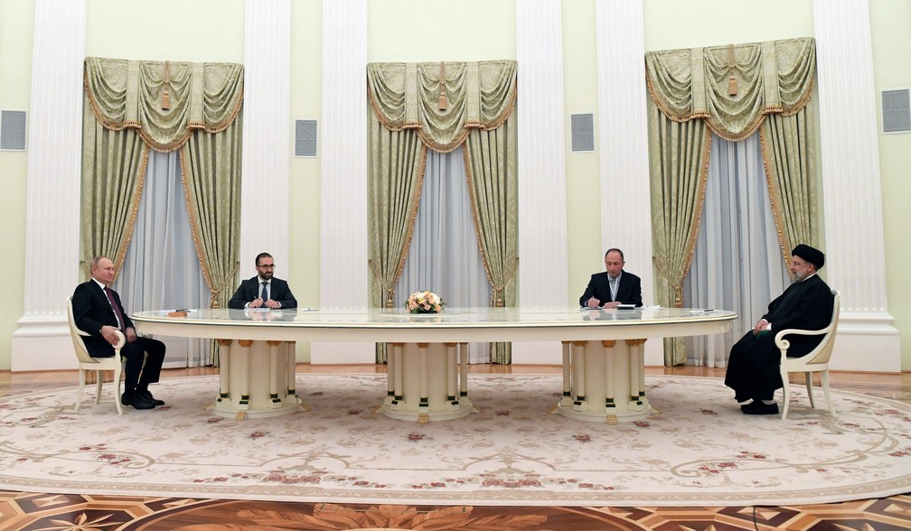 Vladimir Putin e Ebrahim Raisi sentam-se à mesa em Moscou em 19 de janeiro de 2022 — Foto: Sputnik/Pavel Bednyakov/Pool via Reuters