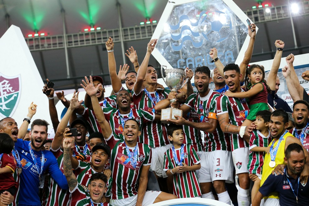 O capitÃ£o Gum ergue a taÃ§a com a ajuda dos companheiros... (Foto: LUCAS MERÃ‡ON / FLUMINENSE F.C.)