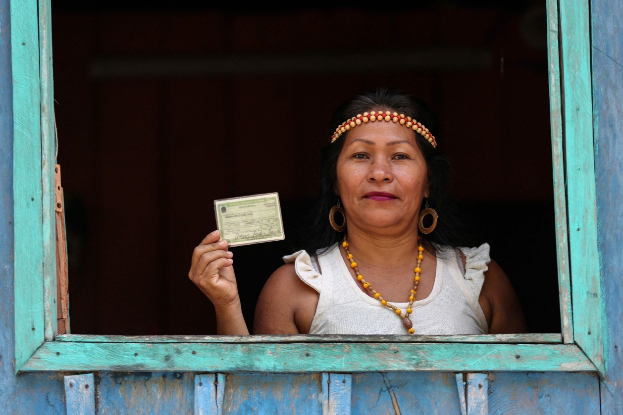 Indígena Kambeba mostra o título de eleitor — Foto: Michael Dantas/AFP
