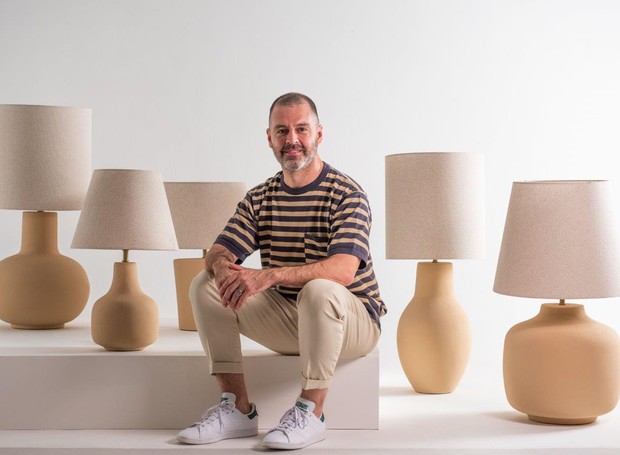 O designer Mauricio Arruda ao lado de sua coleção de abajures criada para a Geo Luz & Cerâmica (Foto: Divulgação)
