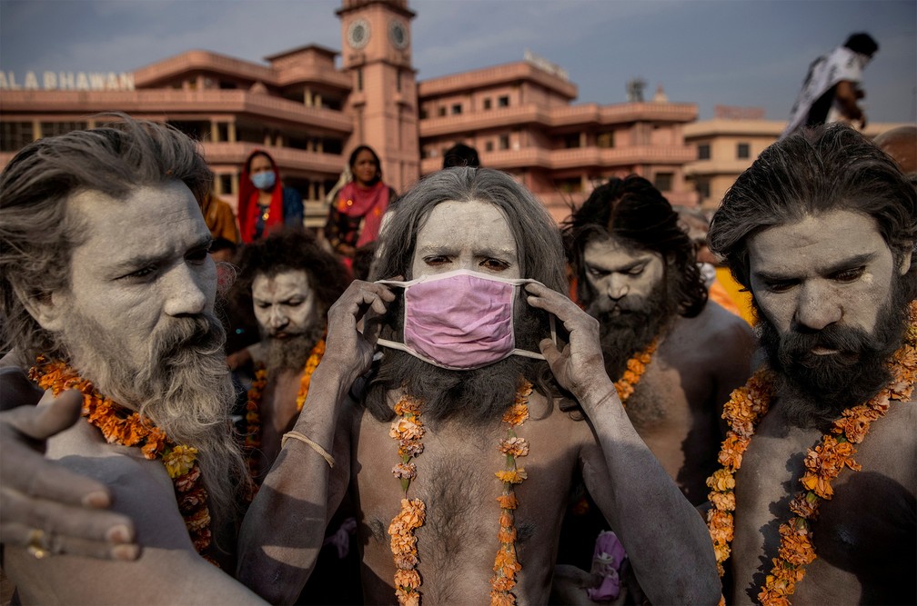 12 de abril - Um naga sadhu, homem santo do Hinduísmo, veste uma máscara antes de procissão para mergulho sagrado no rio Ganges durante festival religioso realizado mesmo em meio ao avanço da pandemia, em Haridwar, na Índia — Foto: Danish Siddiqui/Reuters