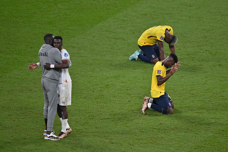Jogadores do Equador prostrados enquanto senegaleses festejam a classificação: isso é Copa do Mundo