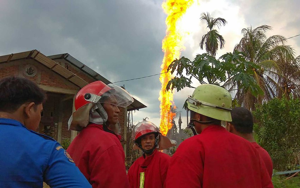 Bombeiros trabalham no local de um incÃªndio em um poÃ§o de petrÃ³leo na provÃ­ncia de Aceh, na IndonÃ©sia (Foto: Ilyas Ismail / AFP PHOTO )