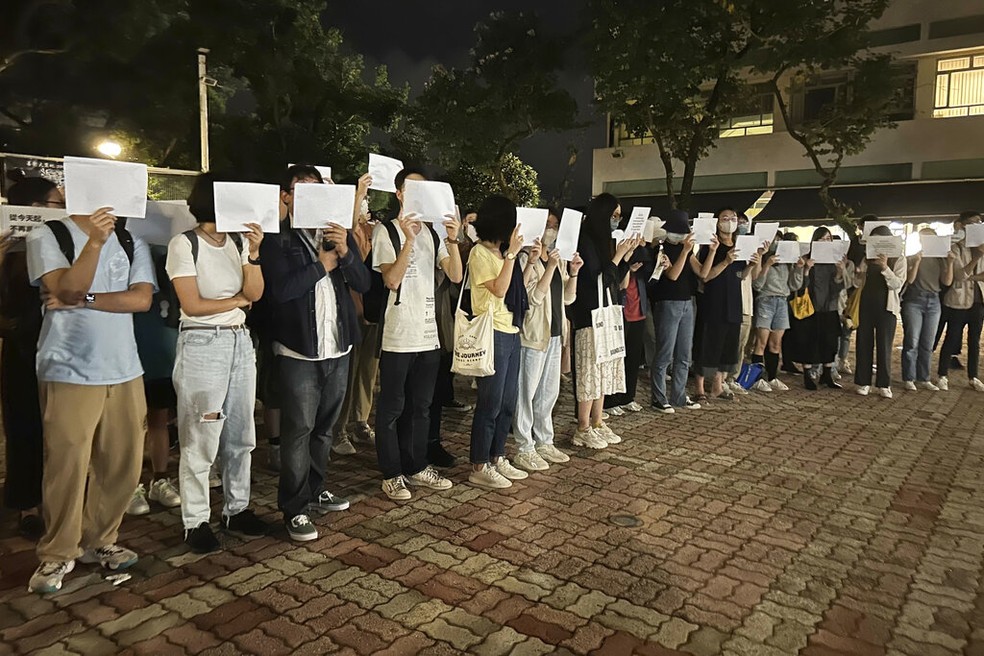 Manifestantes em Urumqi, no oeste da China, protestam com folhas em branco, que viraram símbolo da onda de manifestações que tomou diversas regiões da China, em novembro de 2022. — Foto: Kanis Leung/ AP