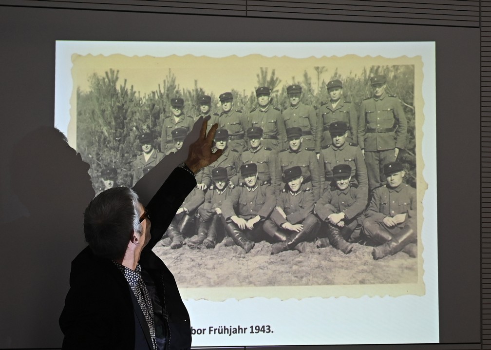 Funcionário da Topografia do Terror, em Berlim, aponta para um homem que supostamente é John Demjanjuk, em uma foto histórica do campo de extermínio nazista de Sobibor, que ficava na Polônia, na época em que o país foi ocupado pela Alemanha durante a Segunda Guerra Mundial. — Foto: Tobias Schwarz / AFP