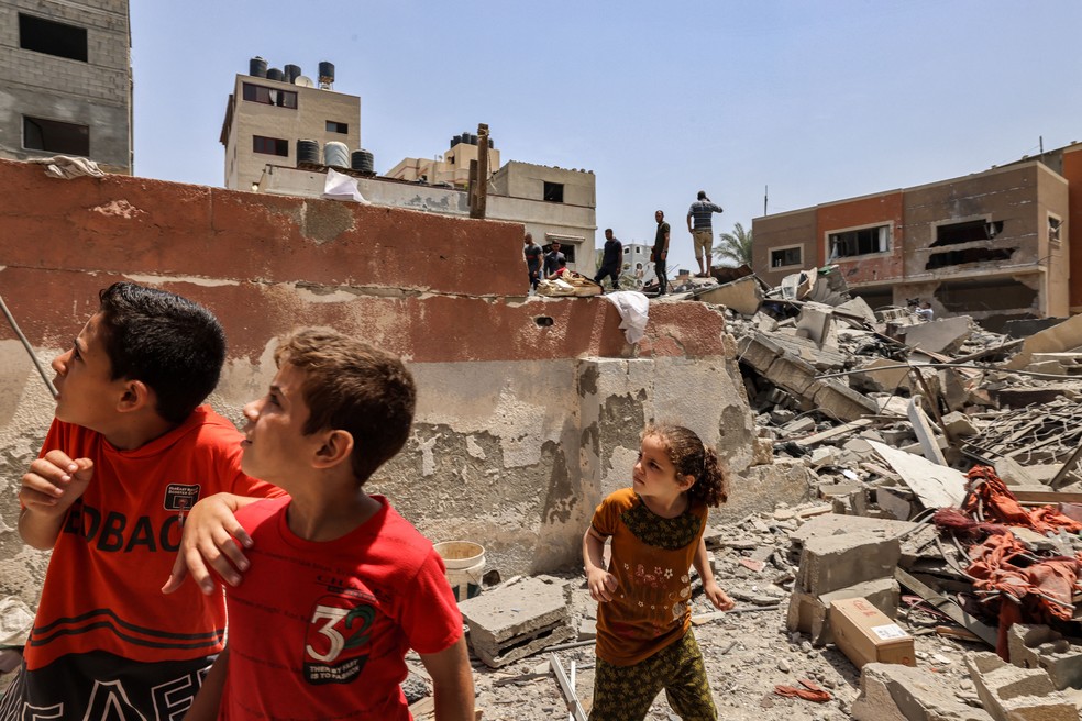 Crianças reagem após um ataque aéreo israelense em Khan Yunis, no sul da Faixa de Gaza, em 6 de agosto de 2022 — Foto: Mohammed Abed/AFP