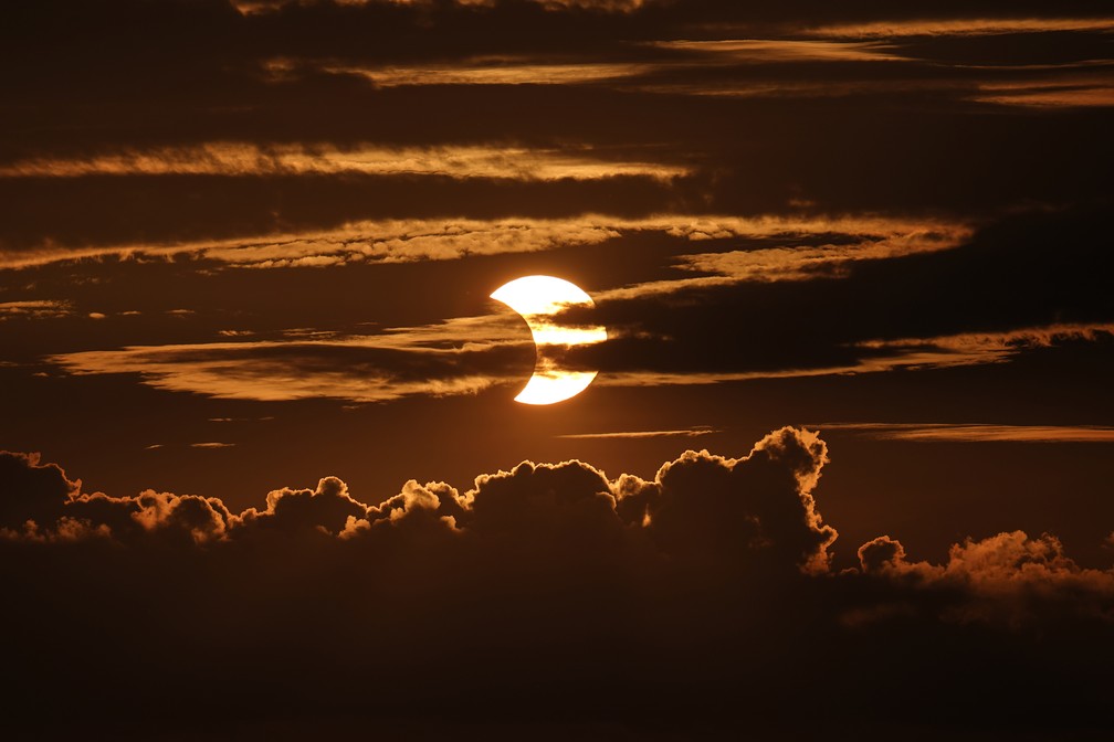 Eclipse solar anular é observado entre nuvens em Arbutus, no estado de Maryland, nos Estados Unidos, no dia 10 de junho — Foto: Julio Cortez/AP