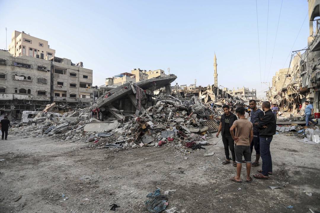 Palestinos inspecionam os danos de edifcios destrudos causados pelos ataques areos israelenses em andamento na Cidade de Gaza