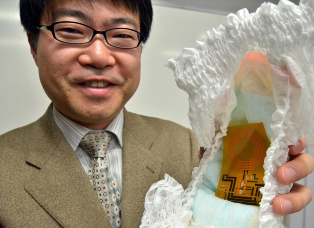 Takao Someya, professor da Universidade de Tóquio, segura seu invento: a primeira fralda com sensor orgânico que avisa quando precisa ser trocada (Foto: AFP Photo/Yoshikazu Tsuno)
