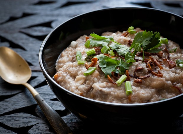 traditional homemade Bubur Lambuk congee in black bowl on wooden carving top (Foto: Getty Images/iStockphoto)