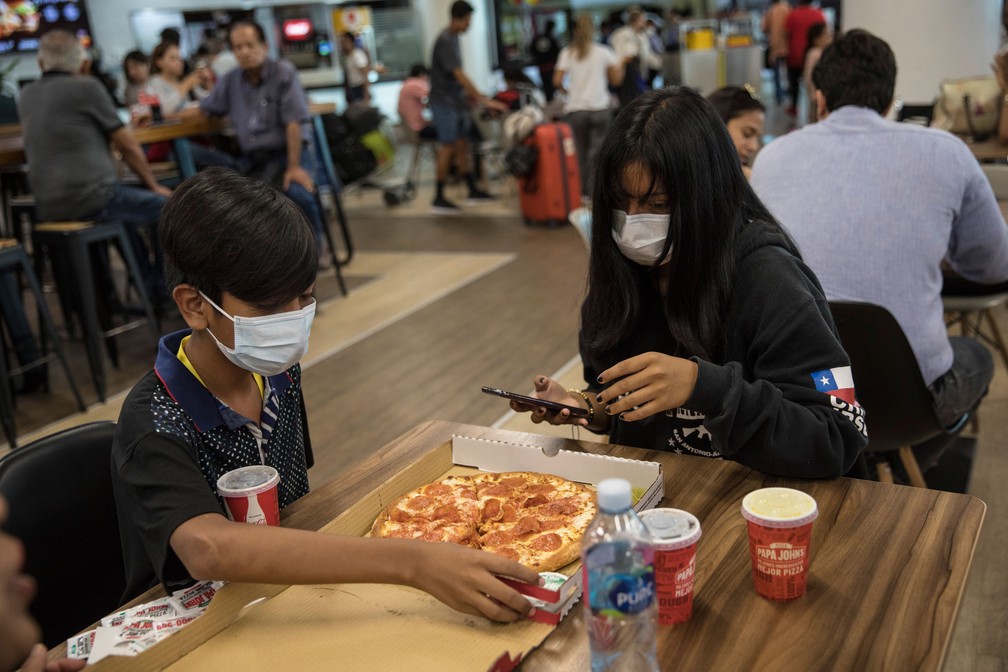 De máscaras, passageiros comem pizza no aeroporto internacional de Lima, no Peru, na sexta-feira (6) — Foto:  Rodrigo Abd/AP 