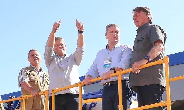 O ex-ministro Tarcísio de Freitas faz sinal de joia ao lado de Bolsonaro (à dir.) e Braga Netto (a esq.) na abertura da feira Agrishow, em Ribeirão Preto 