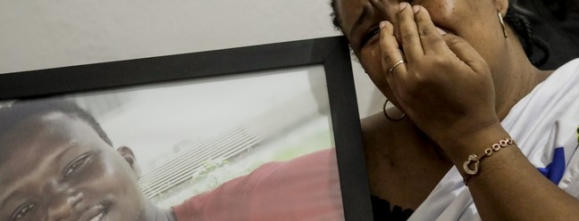 Sofrimento. Lotsove Lolo Lavy Ivone, comerciante congolesa, no Rio desde 2014, abraça o retrato do filho, que foi assassinado na Praia da Barra depois de escapar da guerra em sua terra natal Agência O Globo