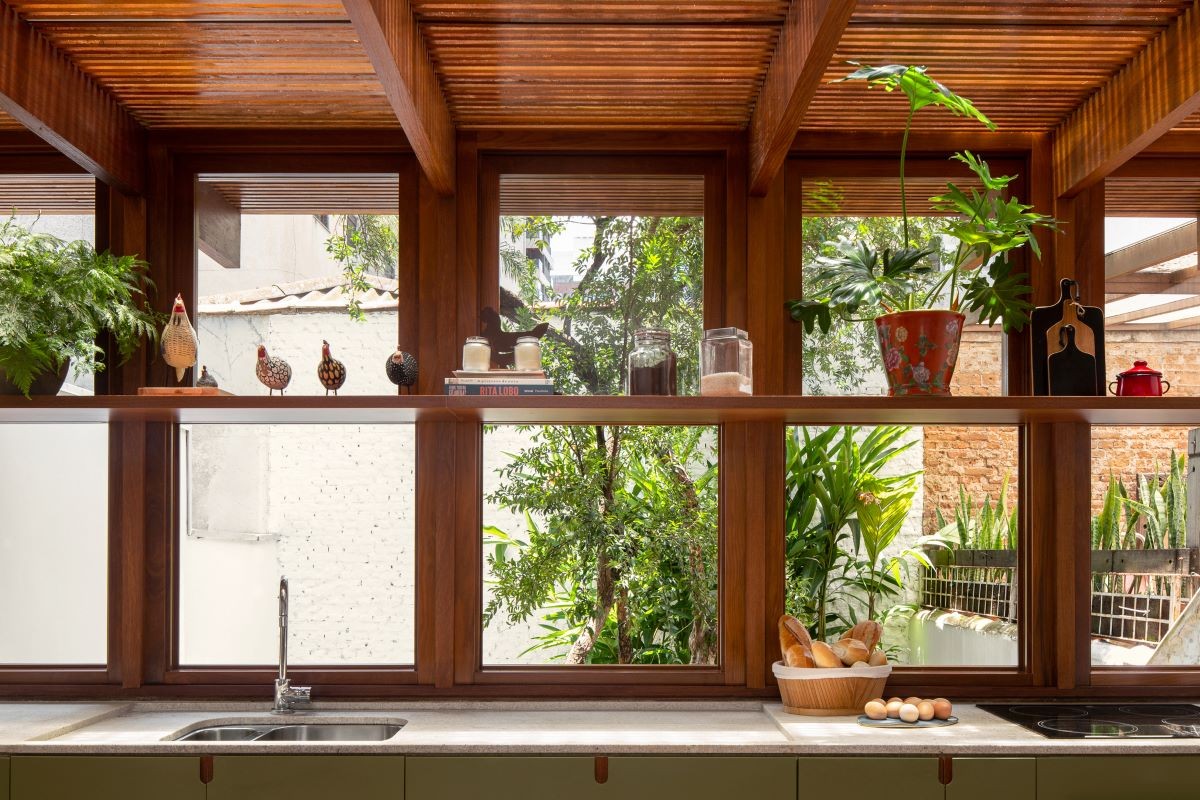 COZINHA | A madeira é predominante no ambiente. As grandes janelas permitem o contato com o exterior da casa (Foto: Carolina Lacaz / Divulgação)