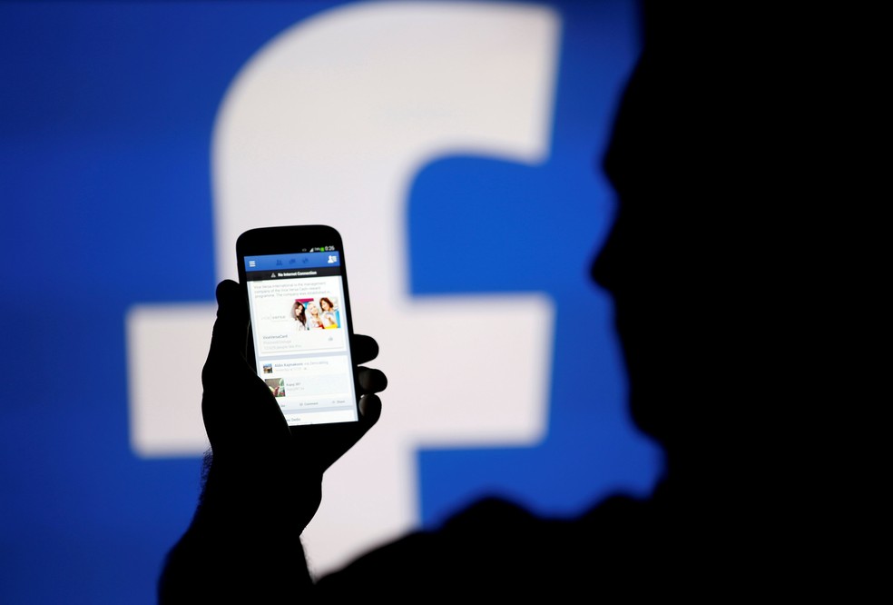 Homem usa aplicativo do Facebook no celular. — Foto: Dado Ruvic/Reuters
