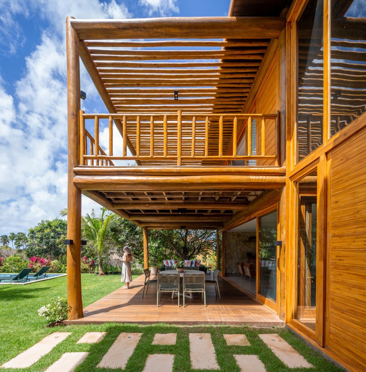 ÁREA EXTERNA | A esquedria móveis de madeira permite controlar a incidência solar em toda a casa (Foto: Manuel Sá / Divulgação)