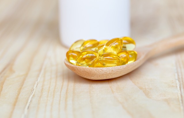 Fish oil capsules with omega 3 and vitamin D on spoon wood with wooden background, healthy diet concept. (Foto: Getty Images)