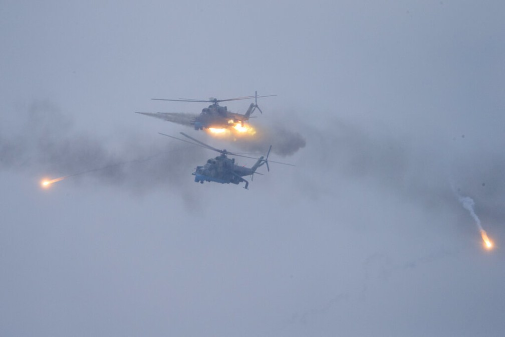 Helicópteros militares disparam sobre o campo de treinamento de Osipovichi durante os exercícios militares perto de Osipovichi, na Bielorrússia, neta quinta-feira, 17. — Foto: Alexander Zemlianichenko Jr/AP