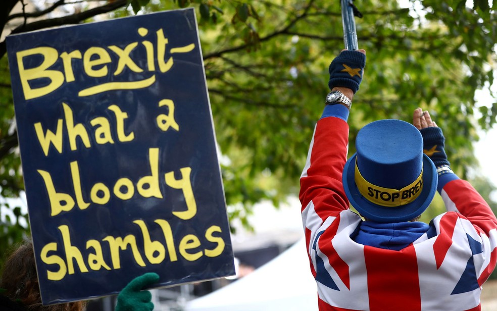 'Brexit - que imensa bagunça', diz cartaz exibido por manifestante em protesto contra a saída do Reino Unido da União Europeia, na terça-feira (21) — Foto: Reuters/Hannah McKay