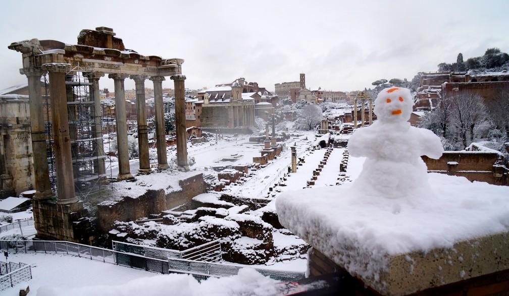 Boneco de neve é visto no Fórum Romano na capital italiana nesta segunda-feira (26) (Foto: Vincenzo Pinto/AFP)