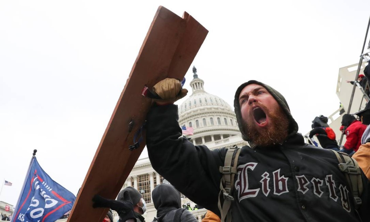 Um homem grita enquanto apoiadores de Trump se reúnem em frente ao prédio do Congresso — Foto: LEAH MILLIS / REUTERS