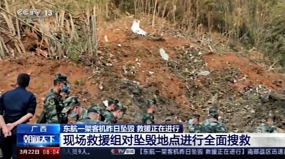 Soldados vasculham o local de um acidente de avião no condado de Tengxian, na Região Autônoma de Guangxi Zhuang, no sul da China, nesta terça-feira (22) — Foto: CCTV via AP Video