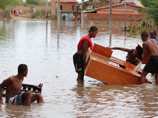 Moradores retiram móveis de casas após rio transbordar (Foto: Divulgação/prefeitura de Riachão do Jacuípe)