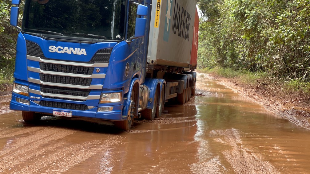 Caminhão precisando fazer "meia-banda" para passar por lamaçal na BR-174 — Foto: Caíque Rodrigues/g1 RR