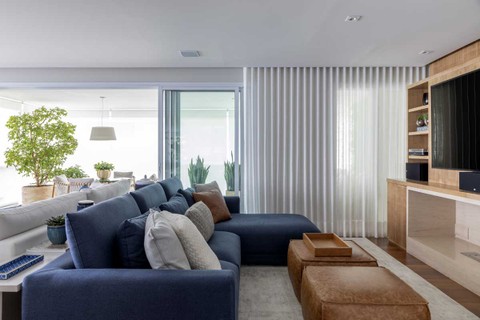No projeto Silvana Lara Nogueira, o azul dá o tom ao apartamento, como neste ambiente com sofás e lareira