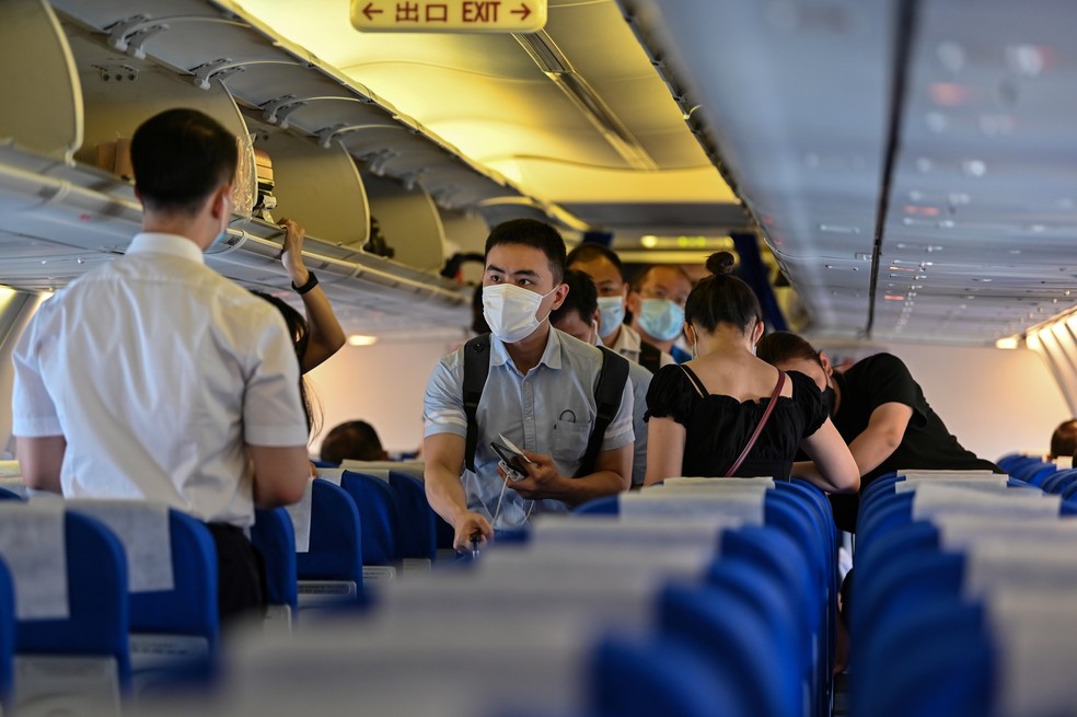 Passageiros utilizando máscaras como medida preventiva contra o coronavírus Covid-19. — Foto: Hector Retamal/AFP