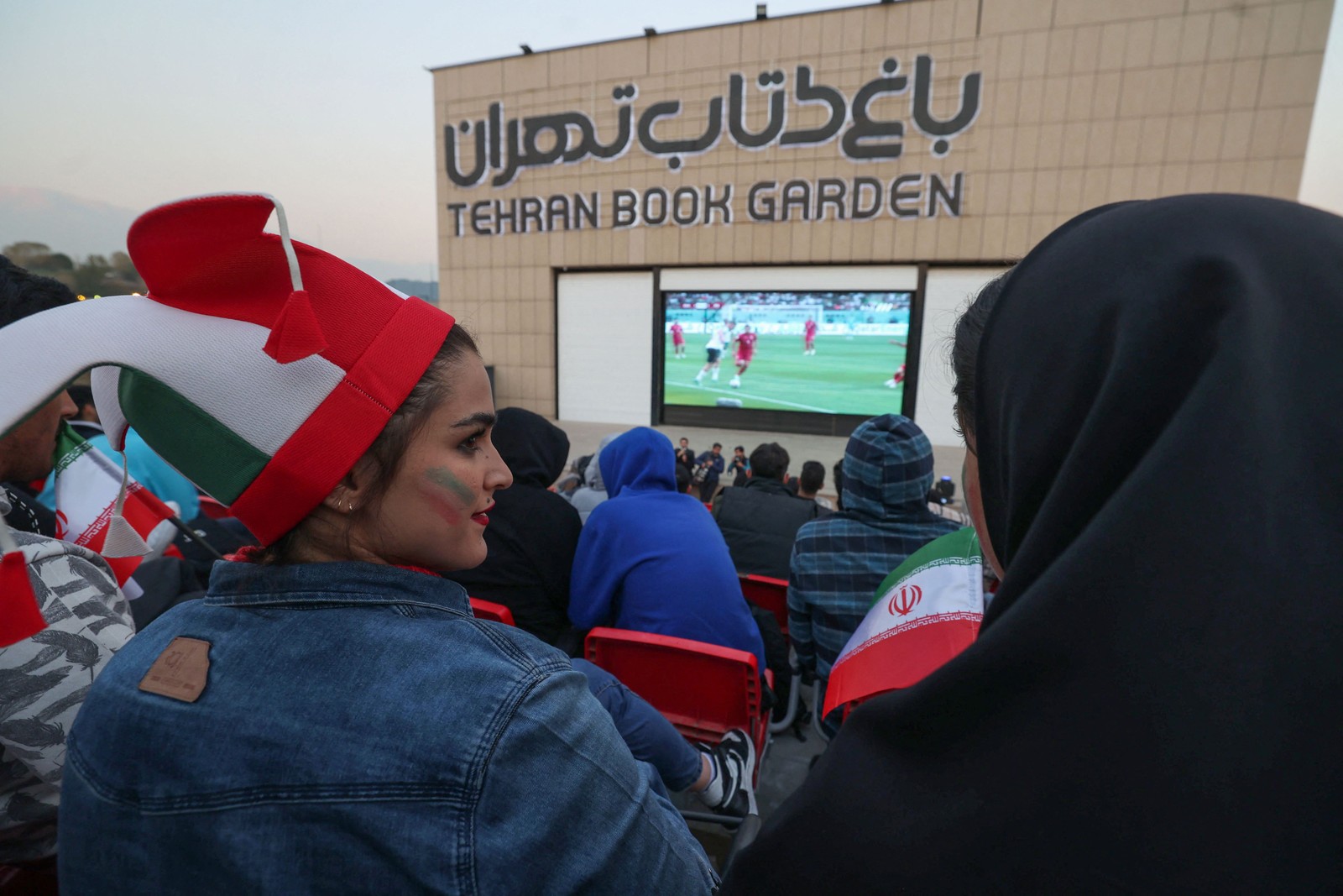 No Irã, onde mulheres são impedidas de ir ao estádio, é possível acompanhar os jogos da seleção em telão montado em Teerã — Foto: ATTA KENARE/AFP